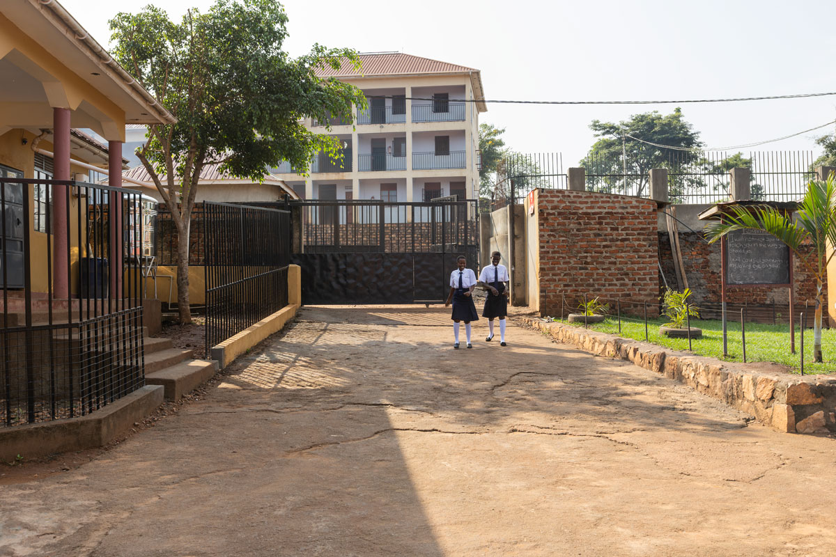 Annet and a fellow classmate walk together in matching school uniforms.